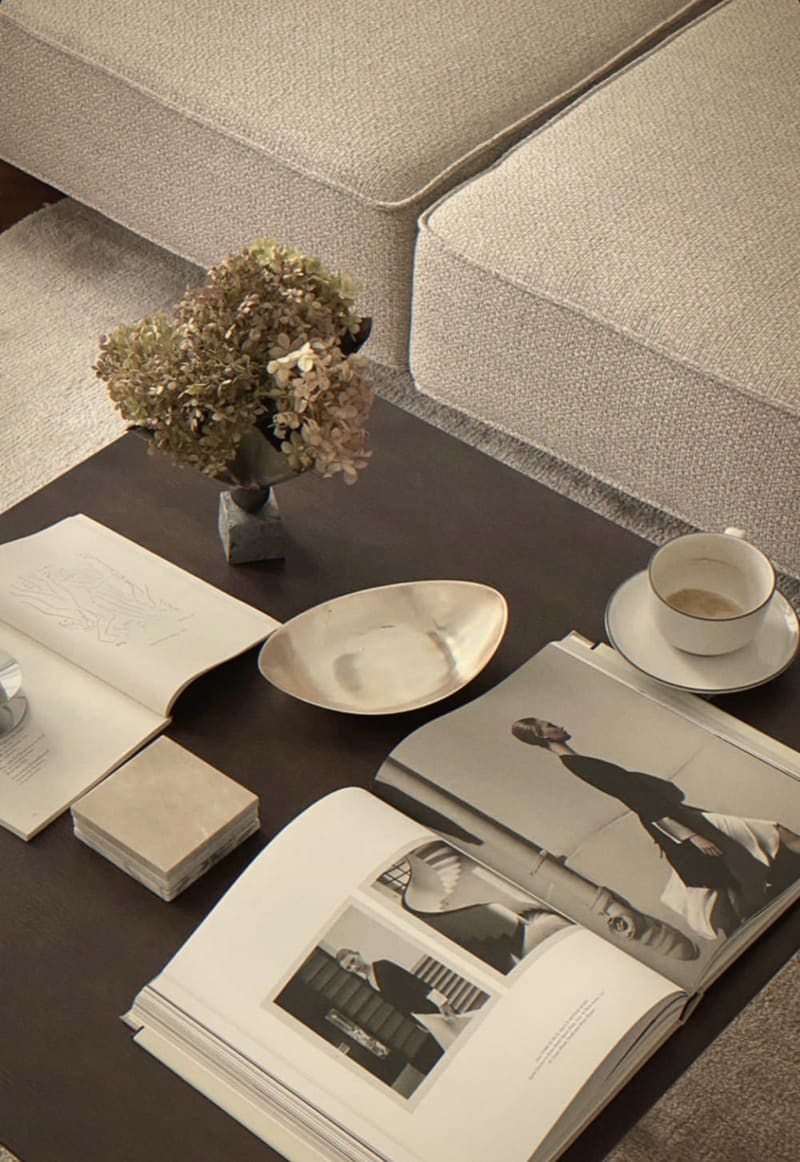 Coffee table styled with open art books, dried hydrangeas and a cup of coffee