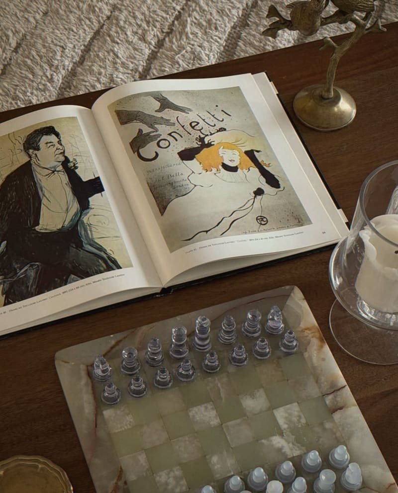 Art book and onyx chess set on a walnut table