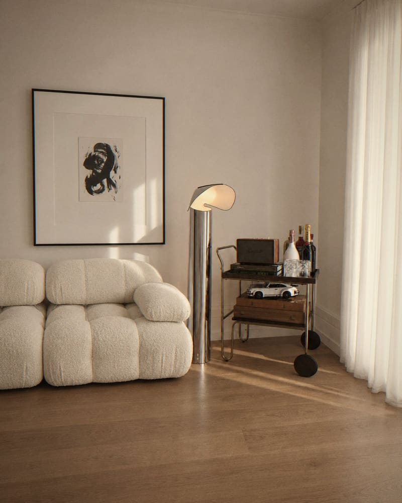 Bouclé sofa, chrome floor lamp and bar cart